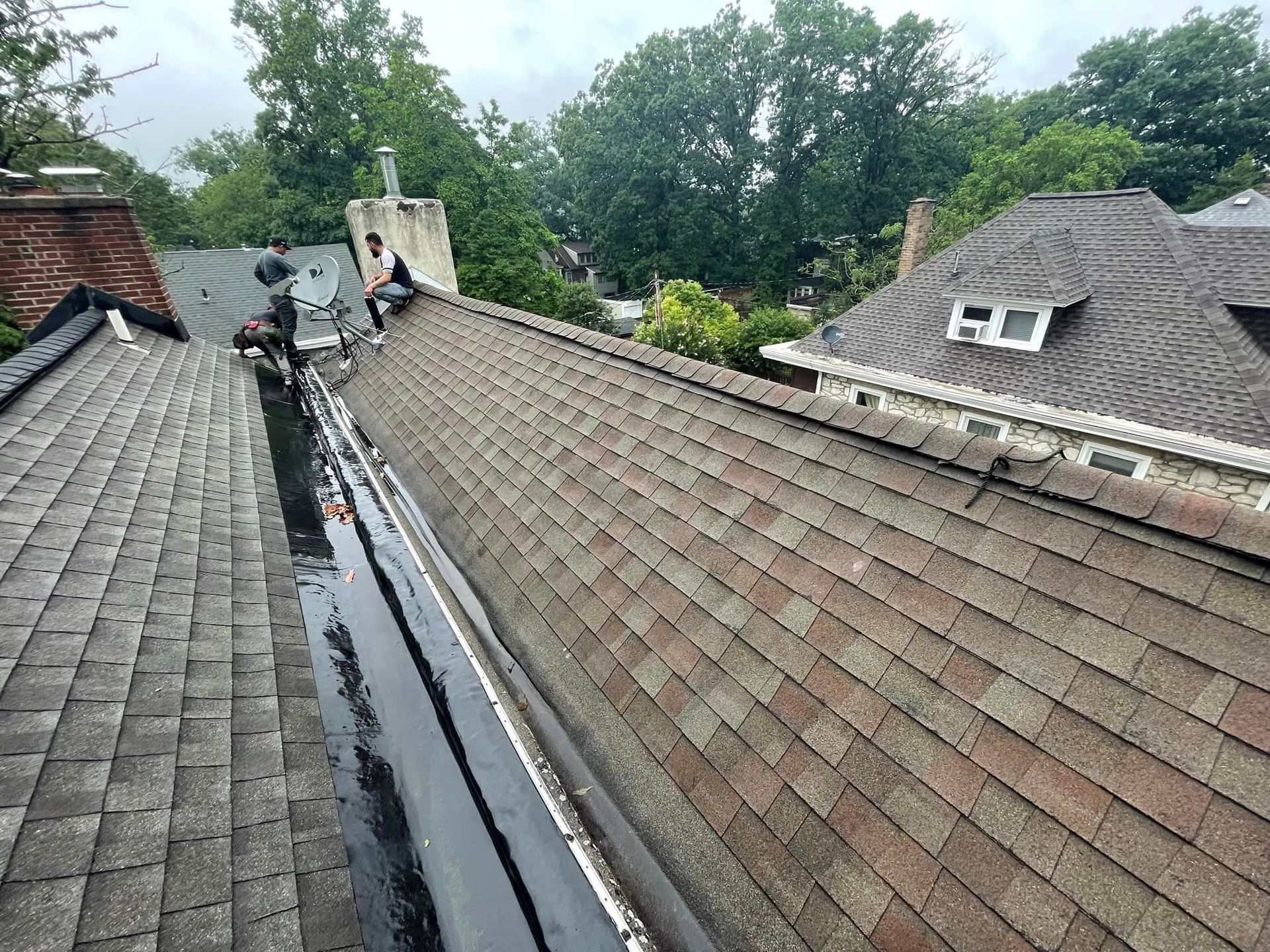 A man is sitting on the roof of a house.
