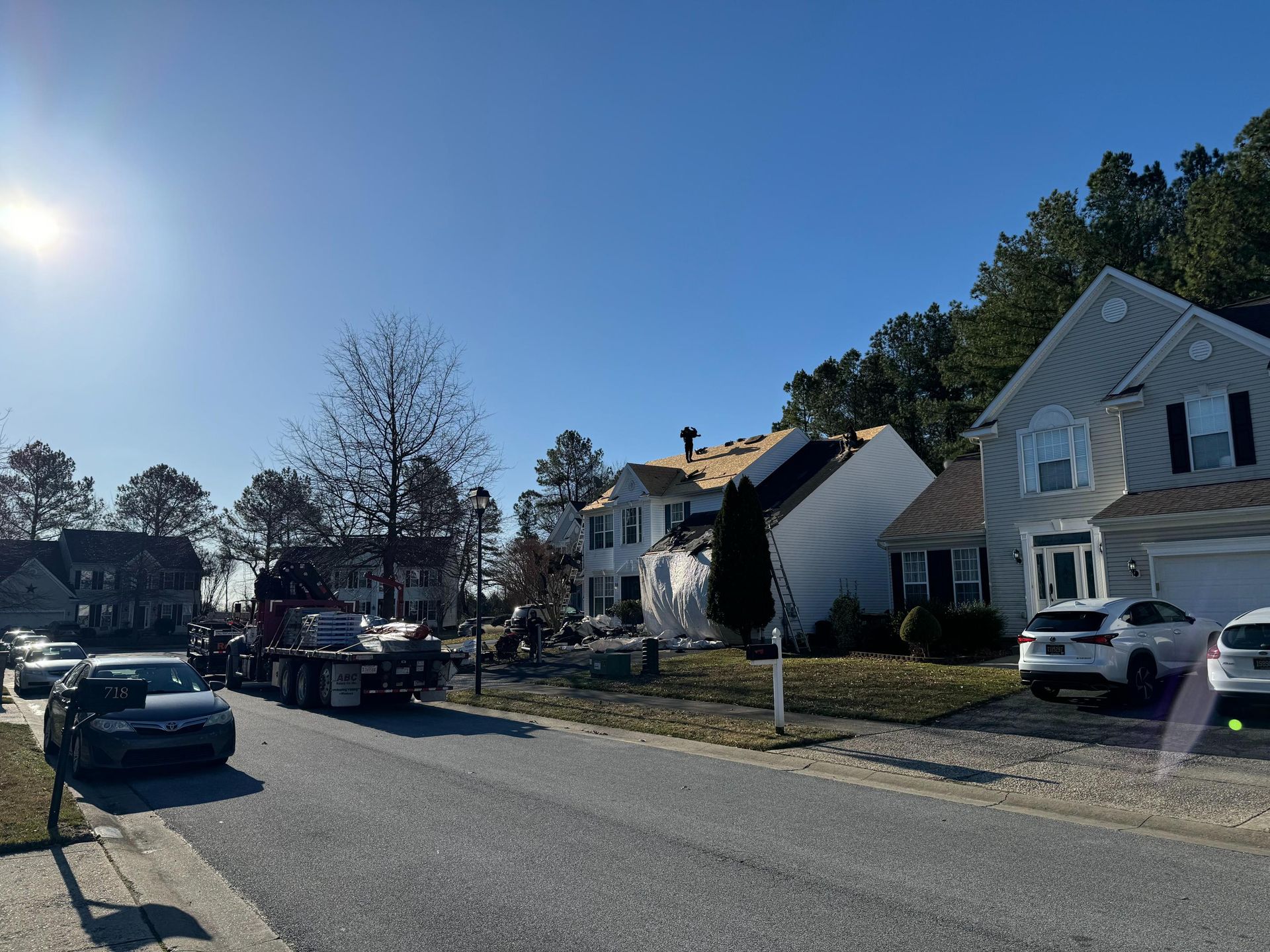 A row of houses on a sunny day with a truck parked on the side of the road.