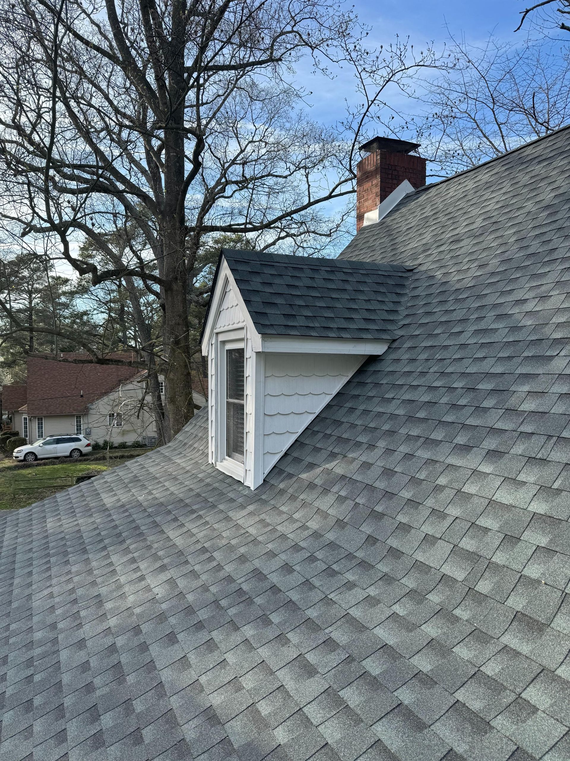 A roof with a window and a chimney on it.