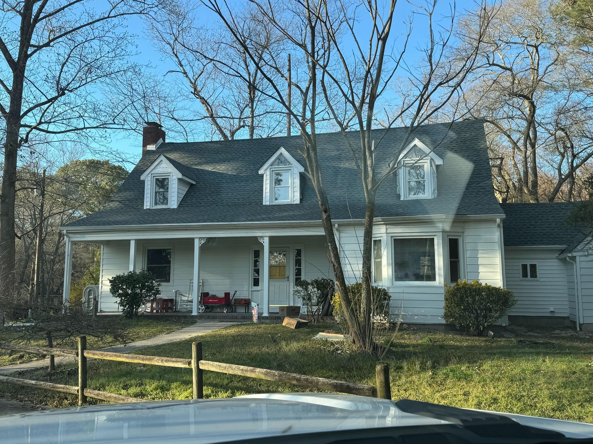 A white house with a blue roof and a porch