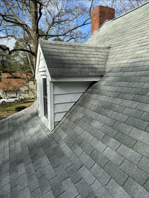 A roof with a window and a chimney on it.