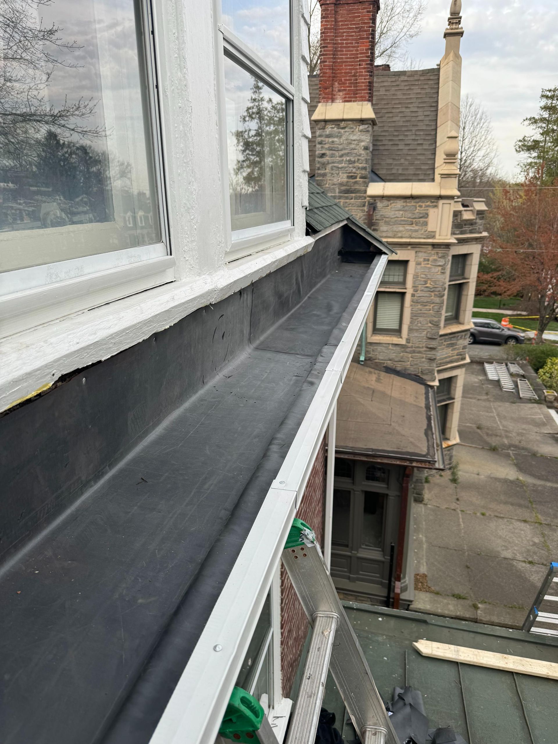A gutter is being installed on the side of a building.