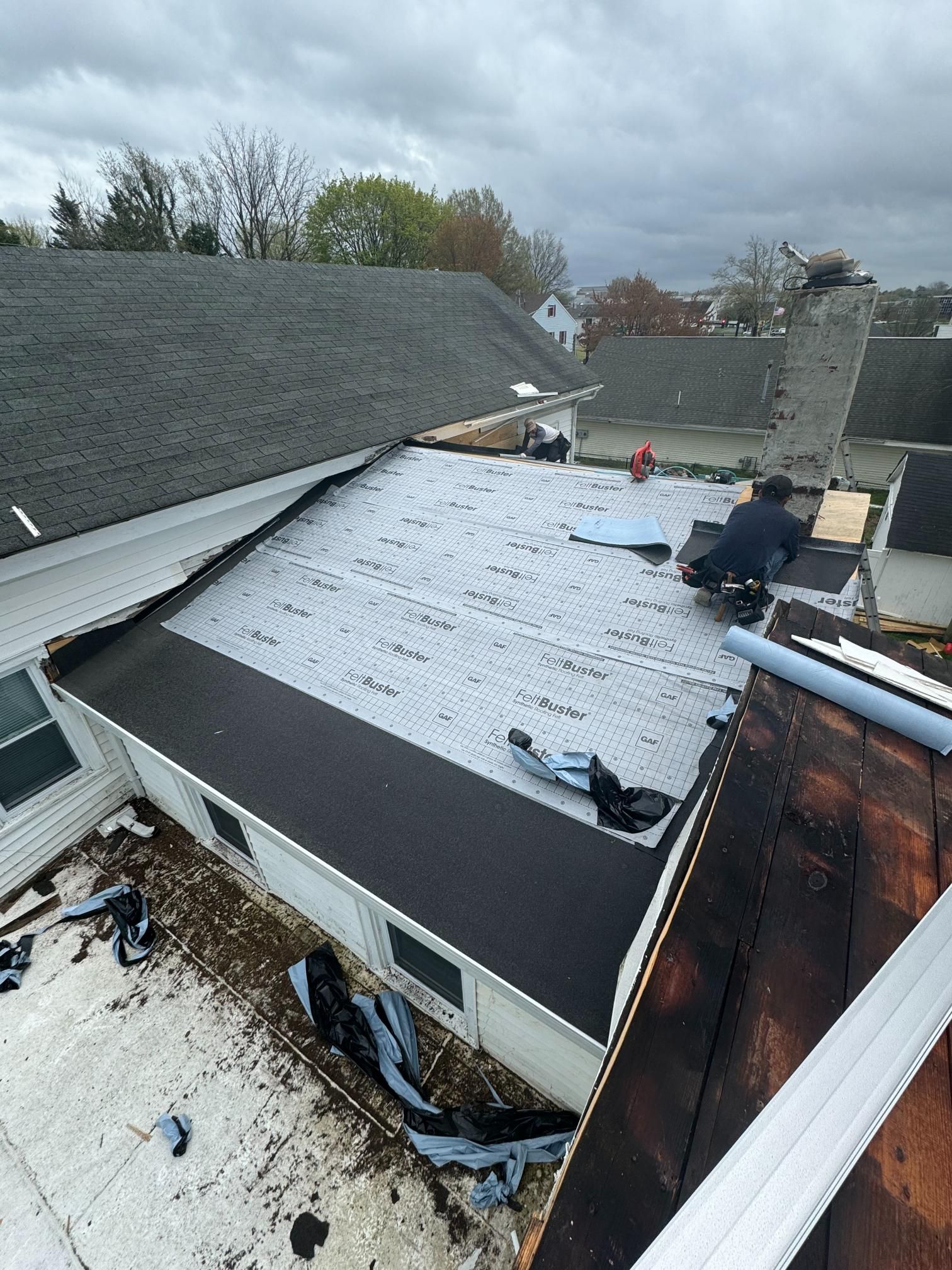 A man is working on the roof of a house.