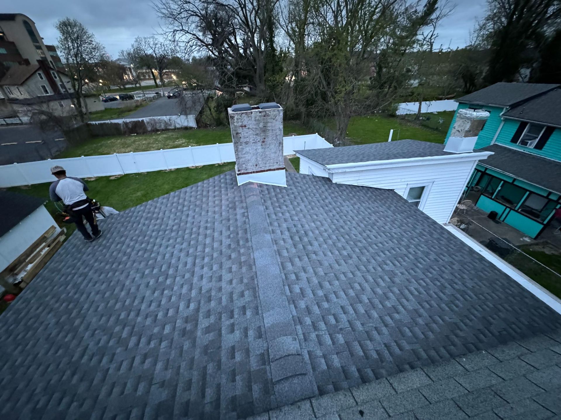 A man is standing on the roof of a house.