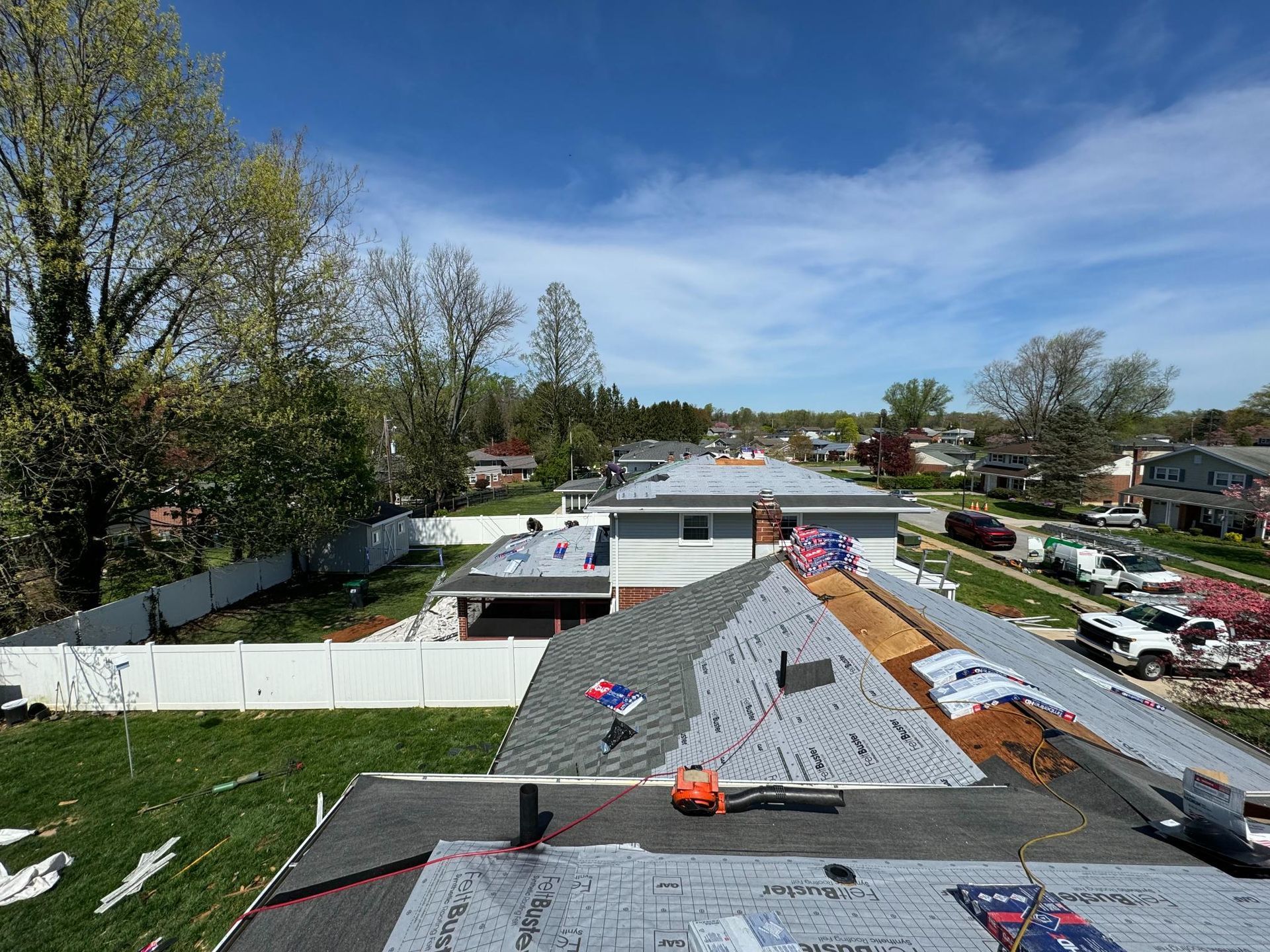 A roof is being installed on a house in a residential area.