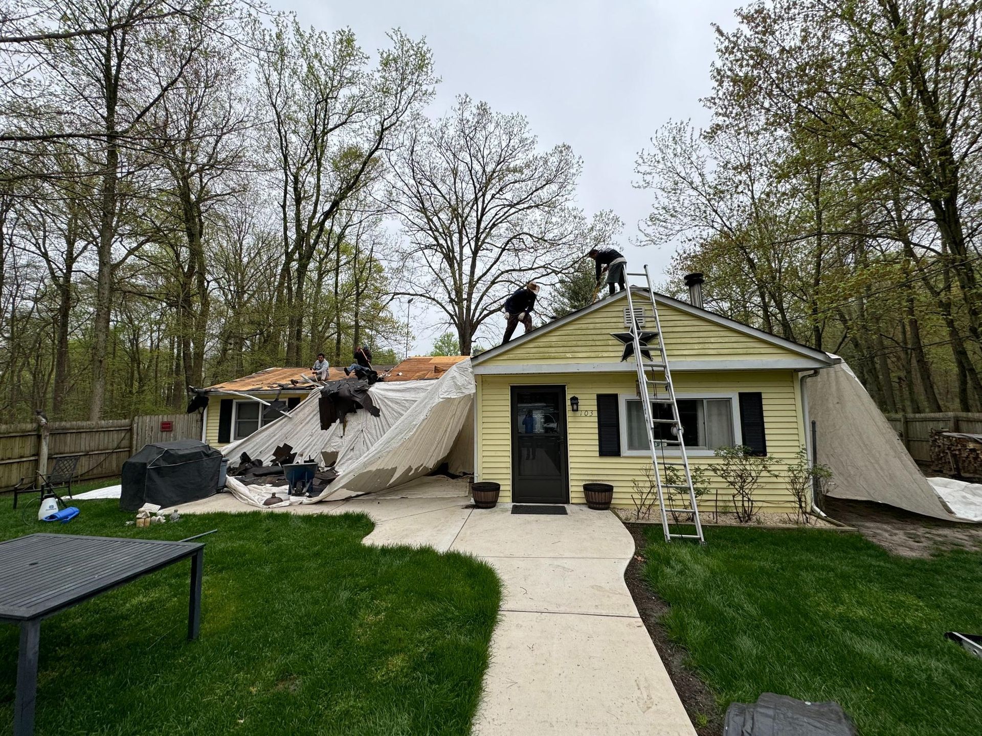 A group of people are working on the roof of a house.