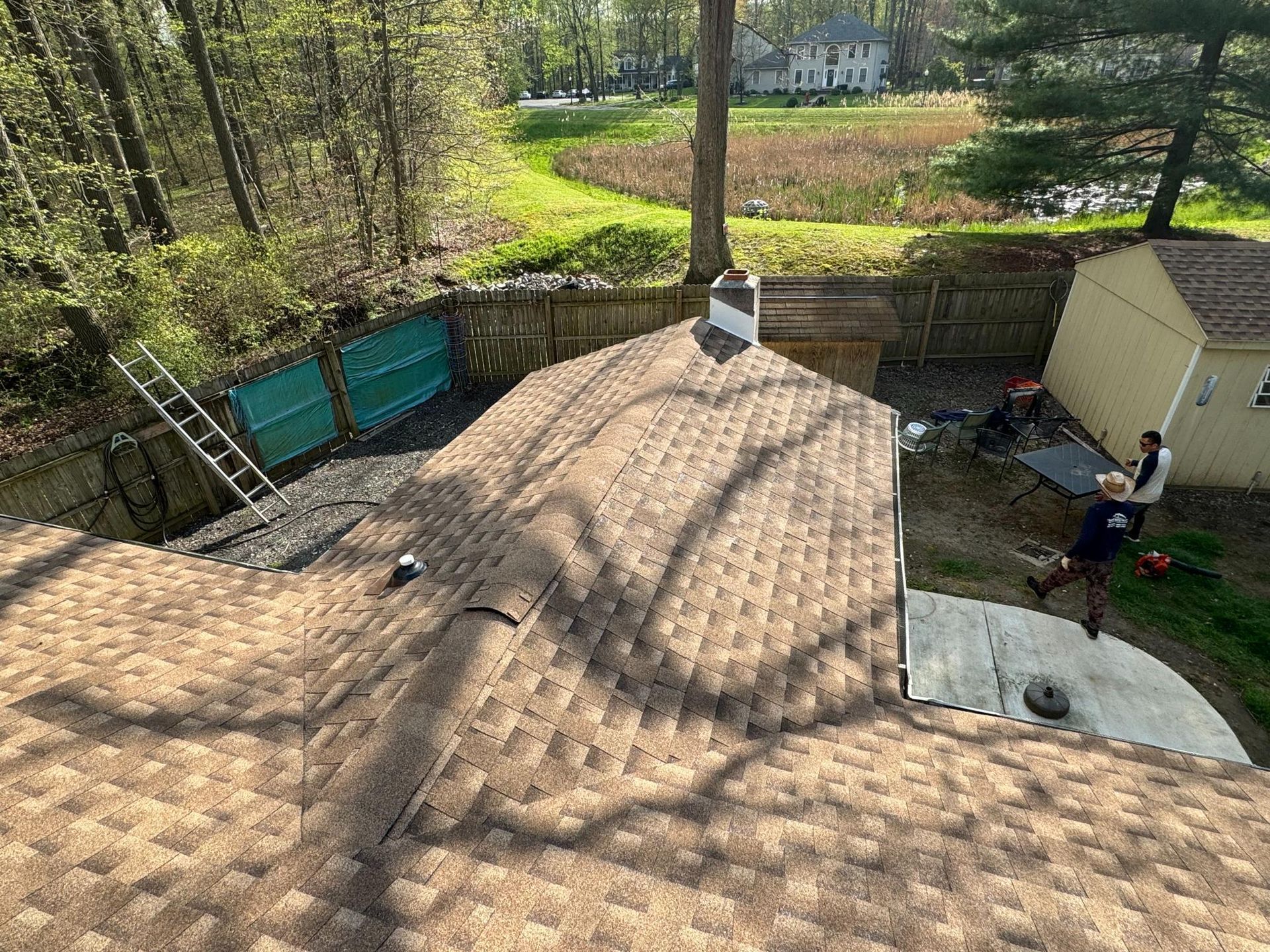 A man is standing on the roof of a house.