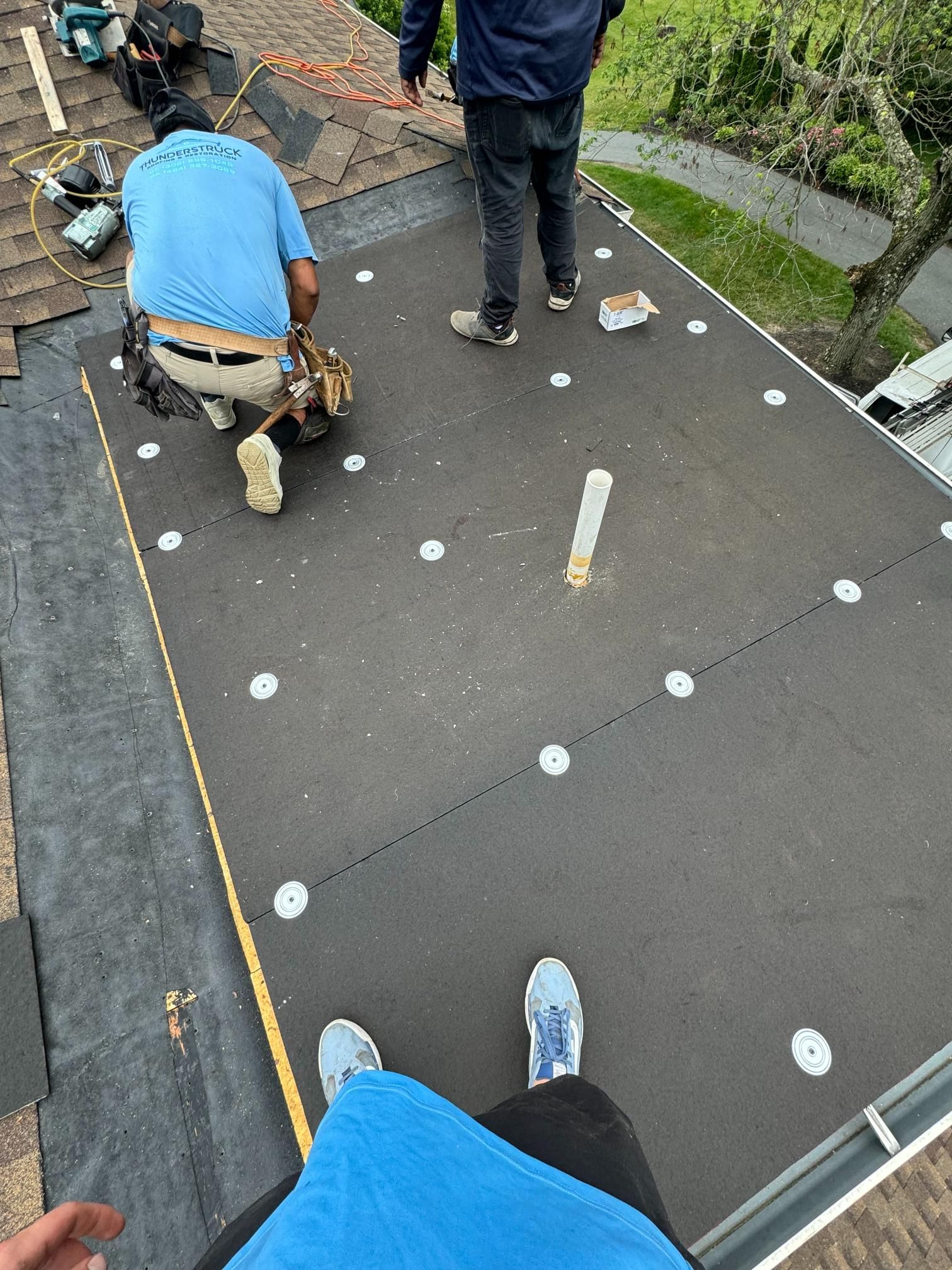 A group of men are working on a roof.