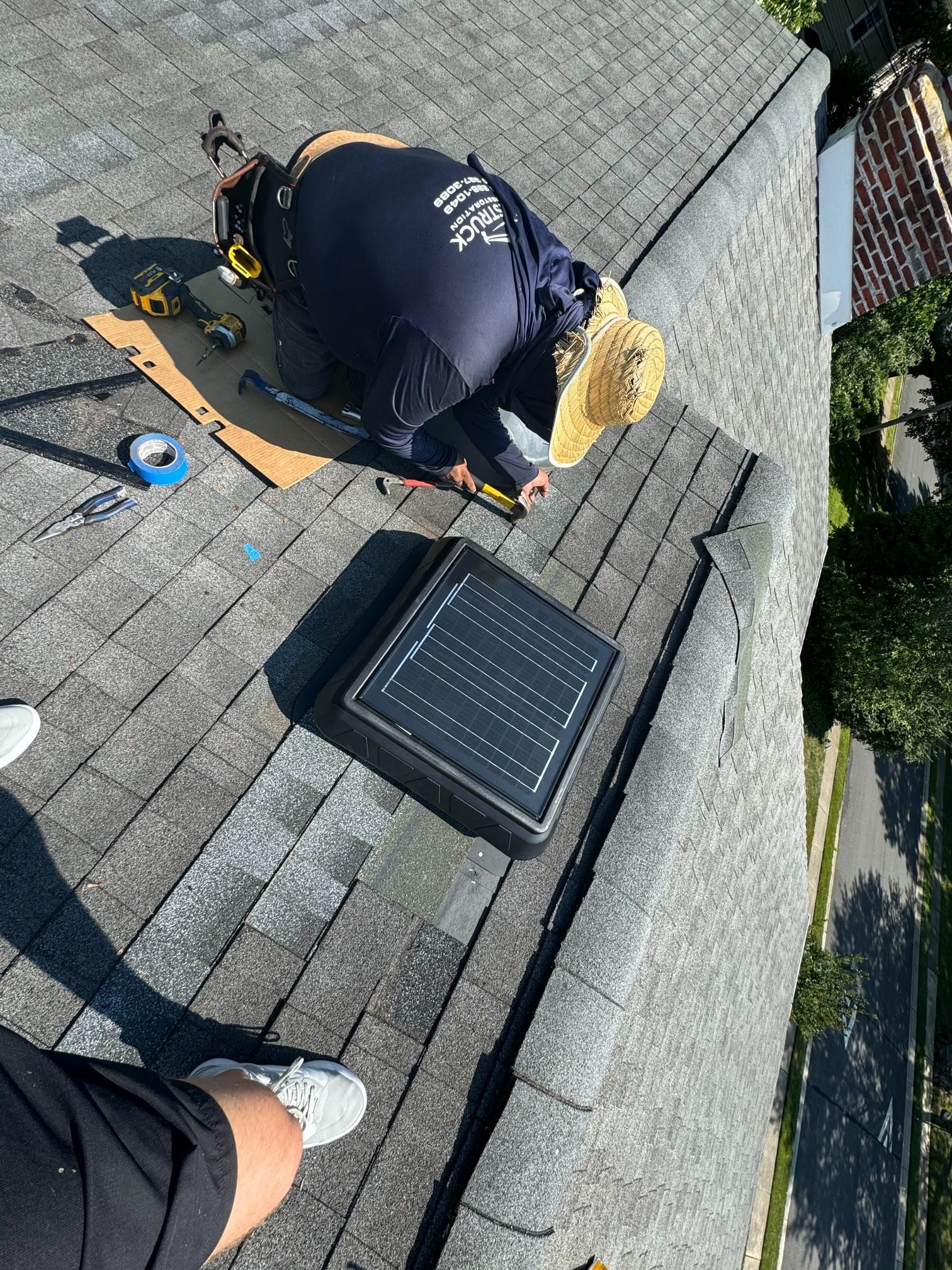 A man is working on a roof with a solar panel.