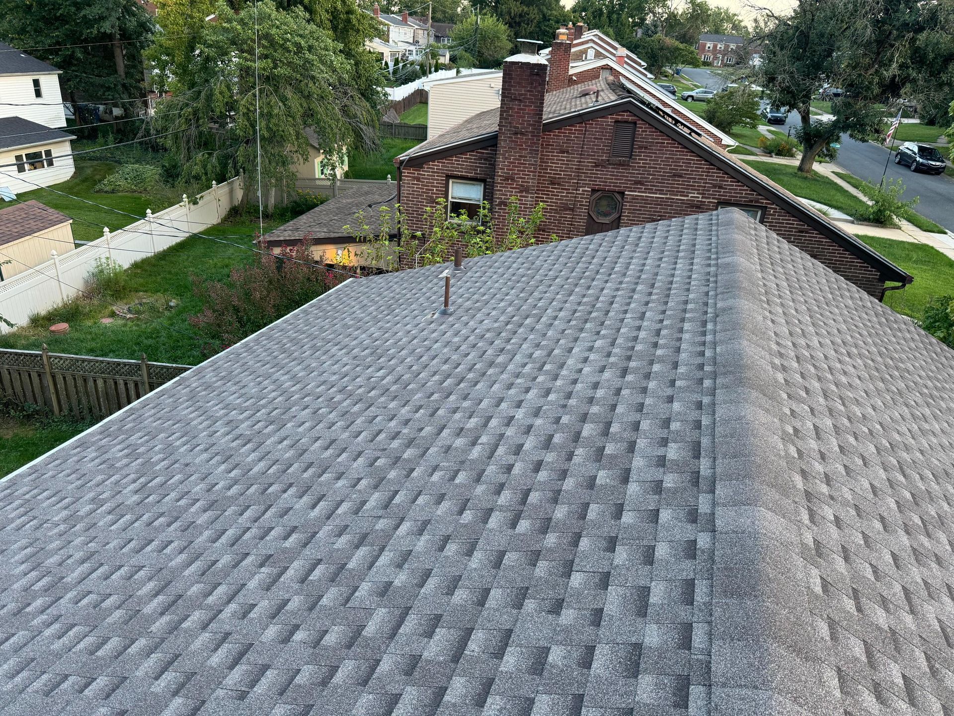 An aerial view of a roof of a house in a residential area.