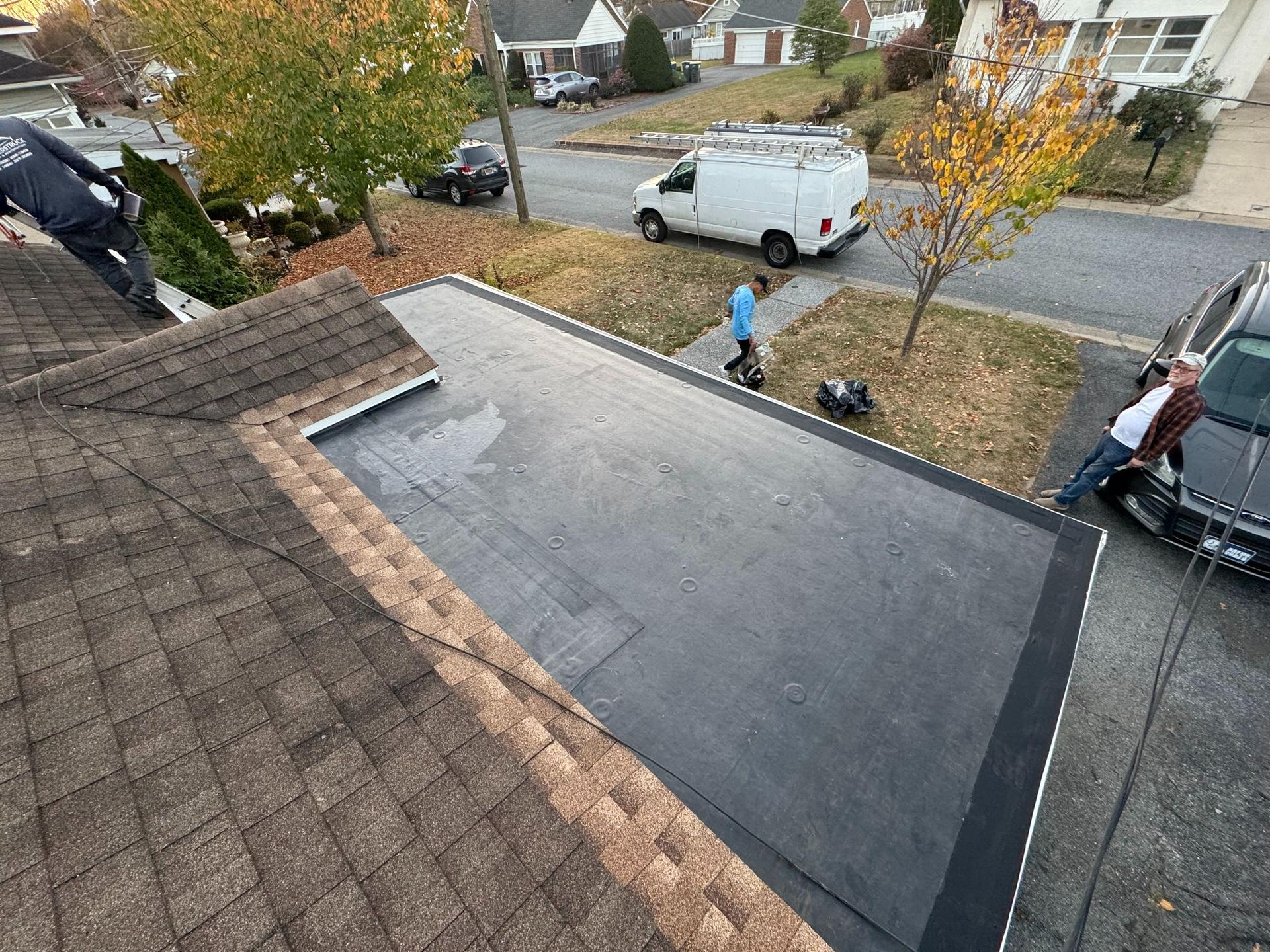 An aerial view of a roof with a van parked on the side of the road.