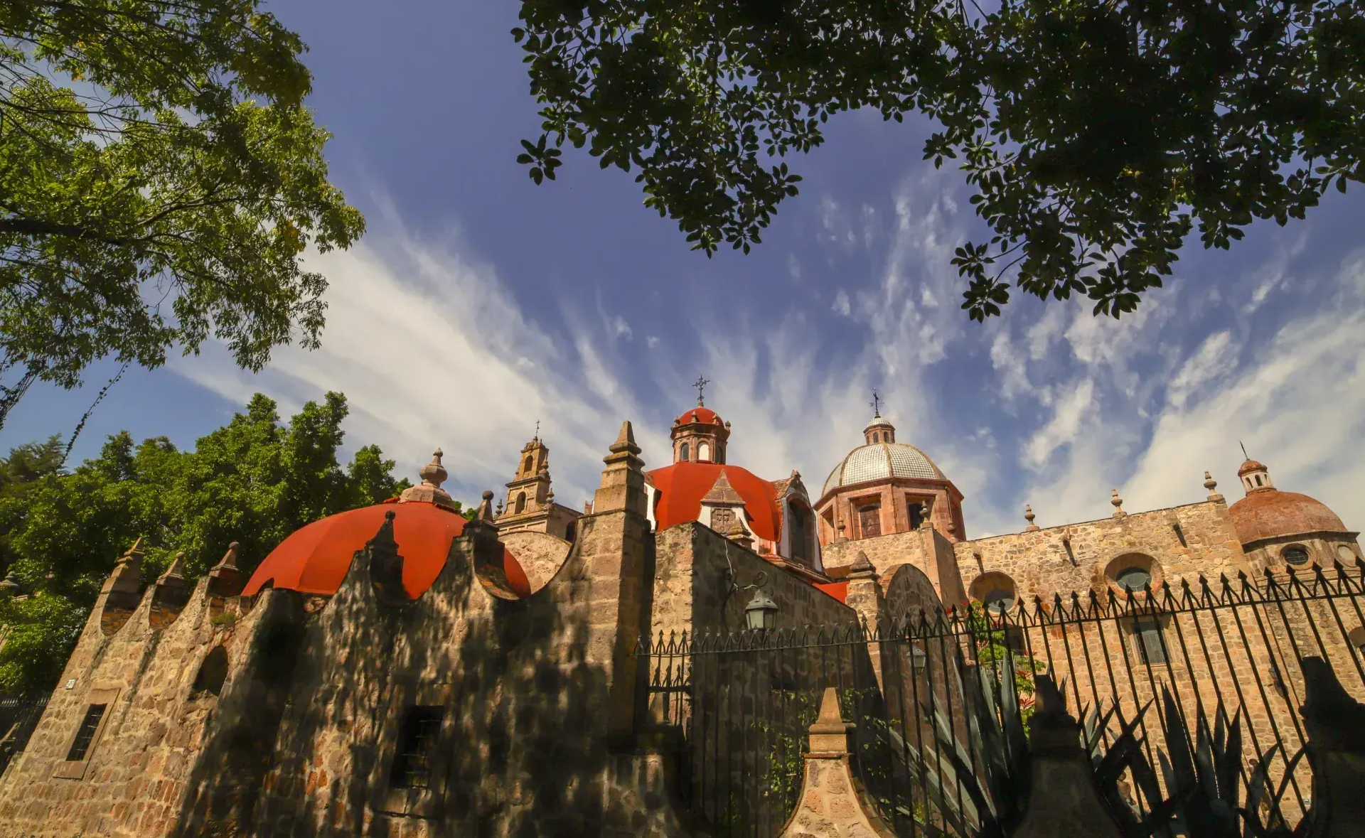 Un castillo con tejados rojos y una valla delante.