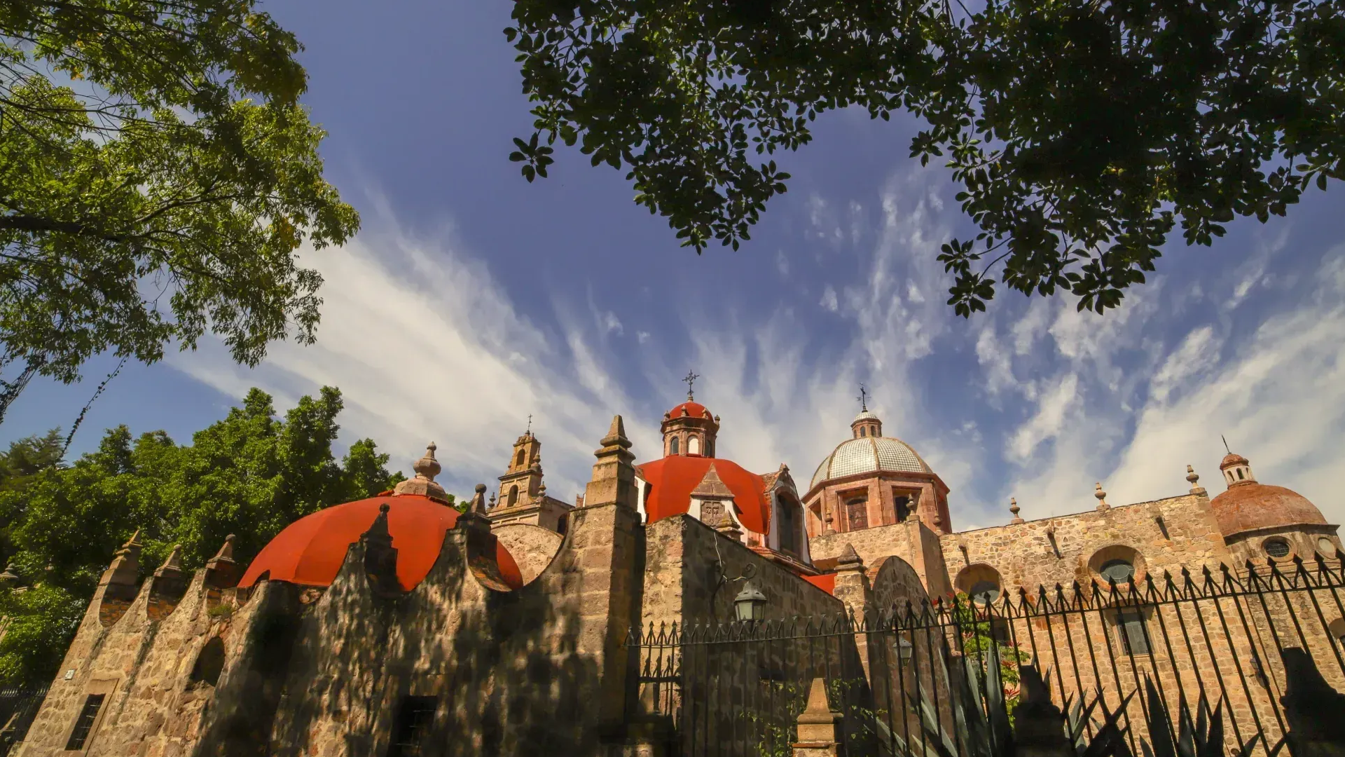 Un castillo con tejados rojos y una valla delante.
