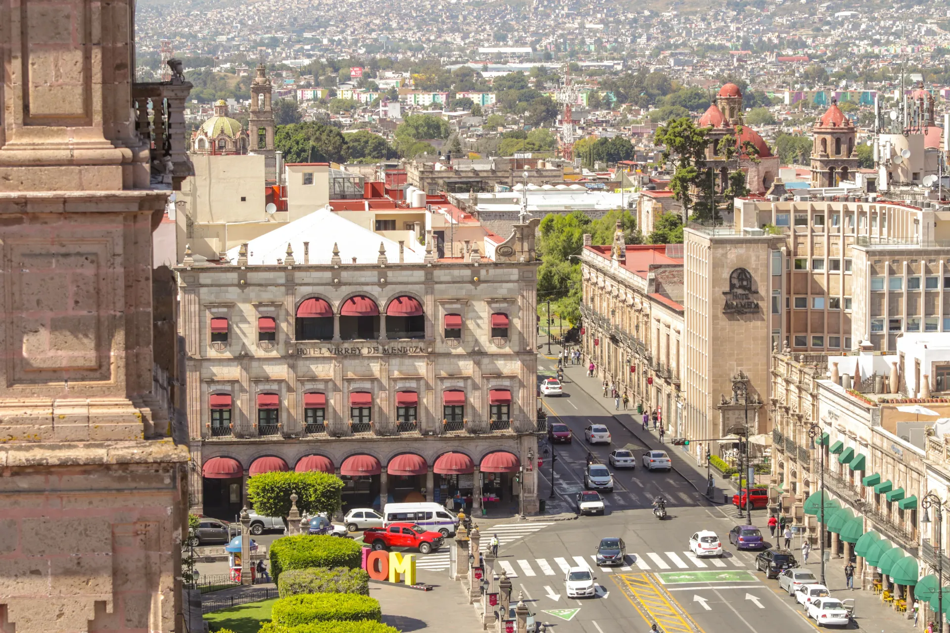 An aerial view of a city street with a large building in the background
