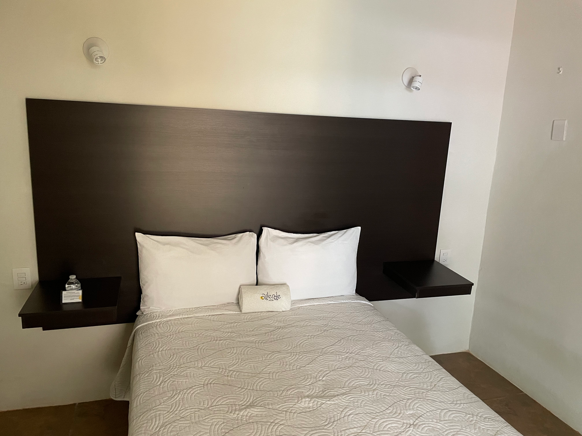 Una habitación de hotel con una cama y un cabecero de madera.