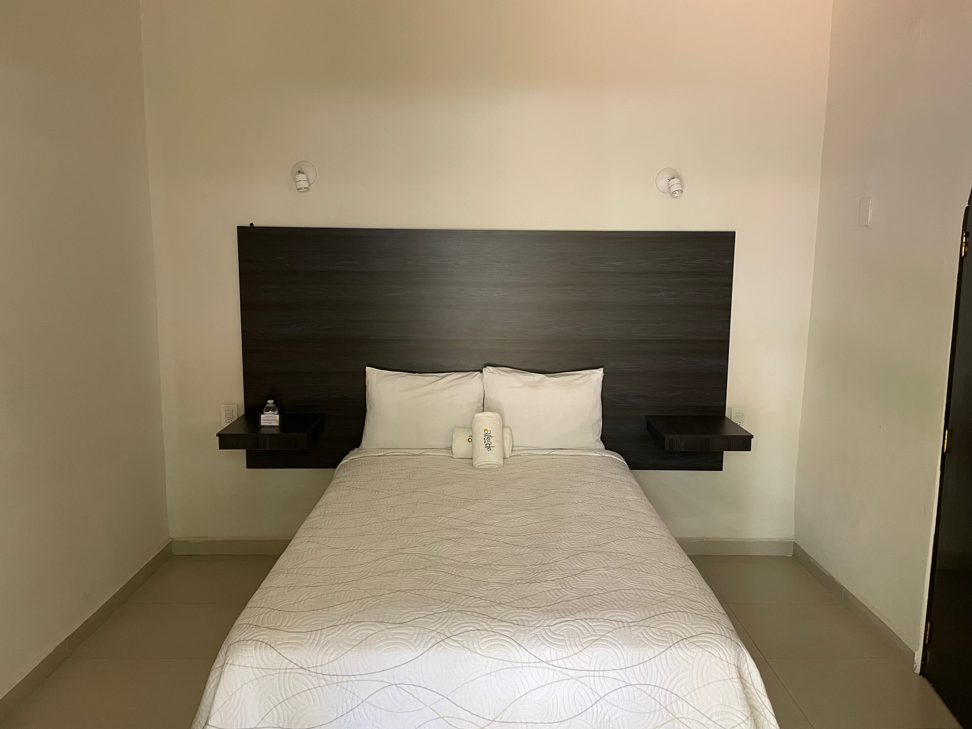 Hay una cama en el medio de la habitación con un cabecero de madera.