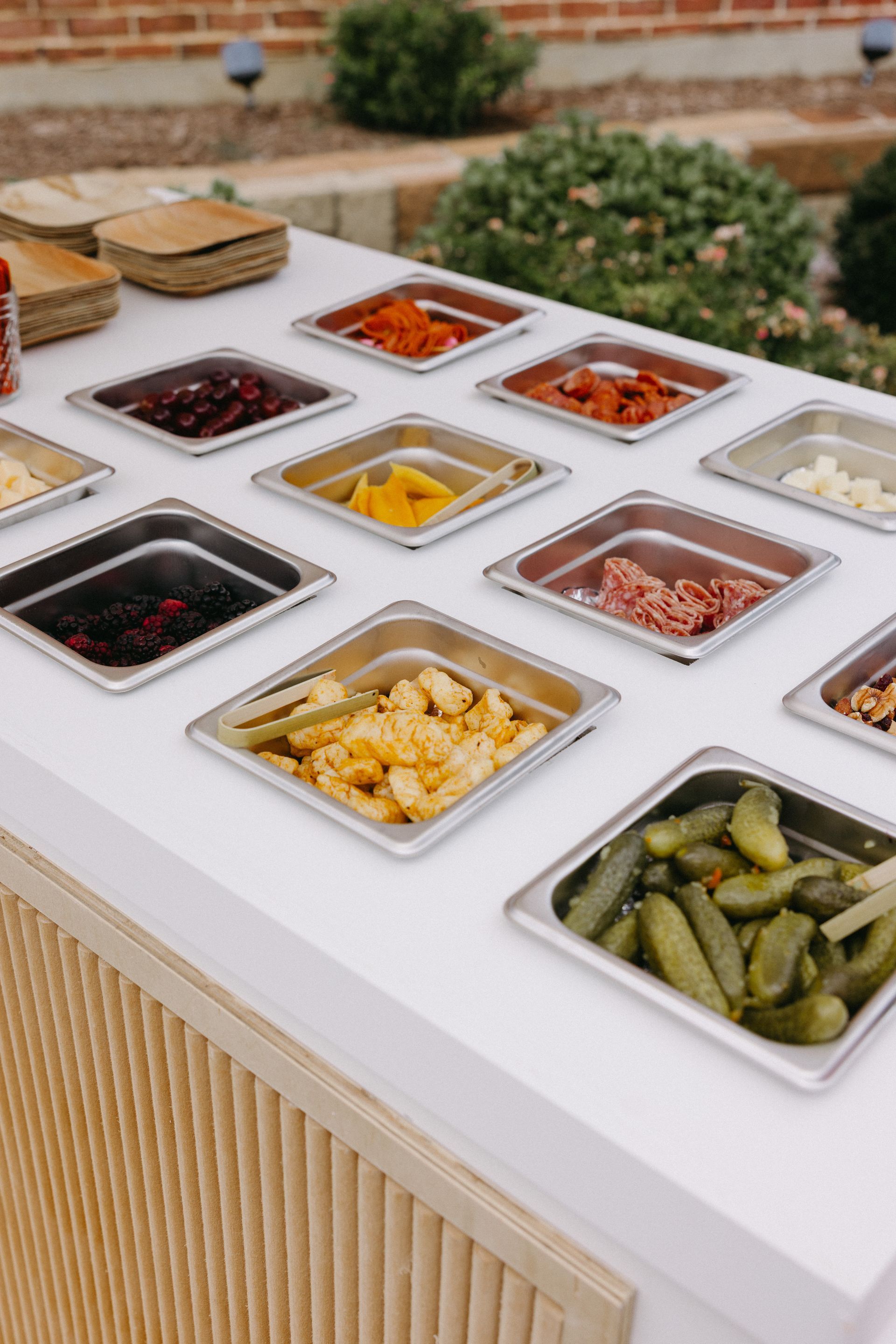 A table topped with a variety of cheeses , crackers , grapes , strawberries and honey.