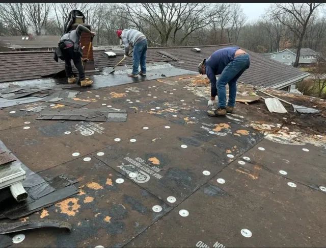 A group of men are working on a roof.