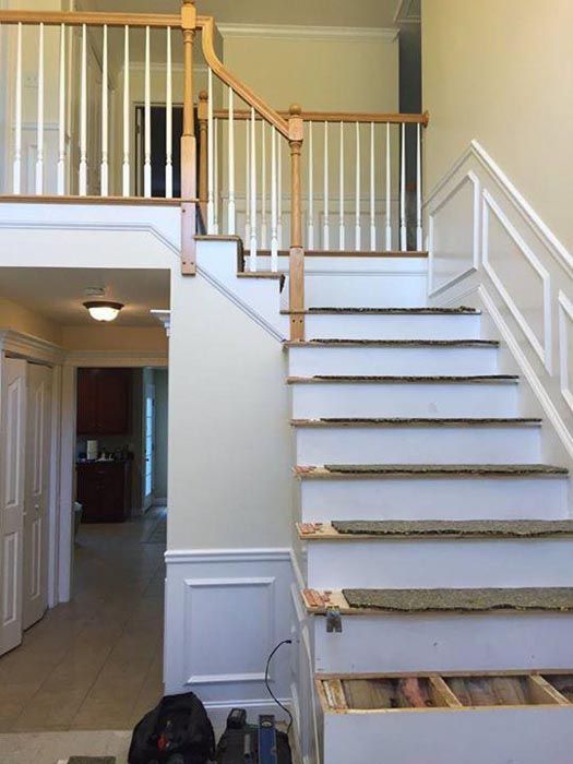 Interior staircase with white railings and unfinished steps in a home hallway