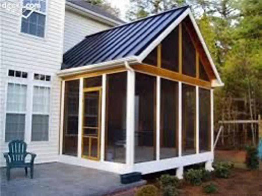 Small screened porch addition with a black metal roof beside a white house.