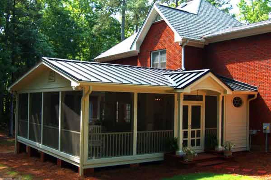 Red brick house with a screened porch and white trim, viewed from the yard