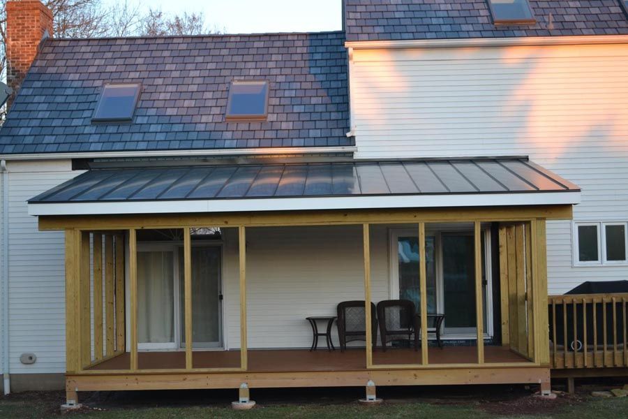 Backyard house with a covered wooden patio and sliding glass doors