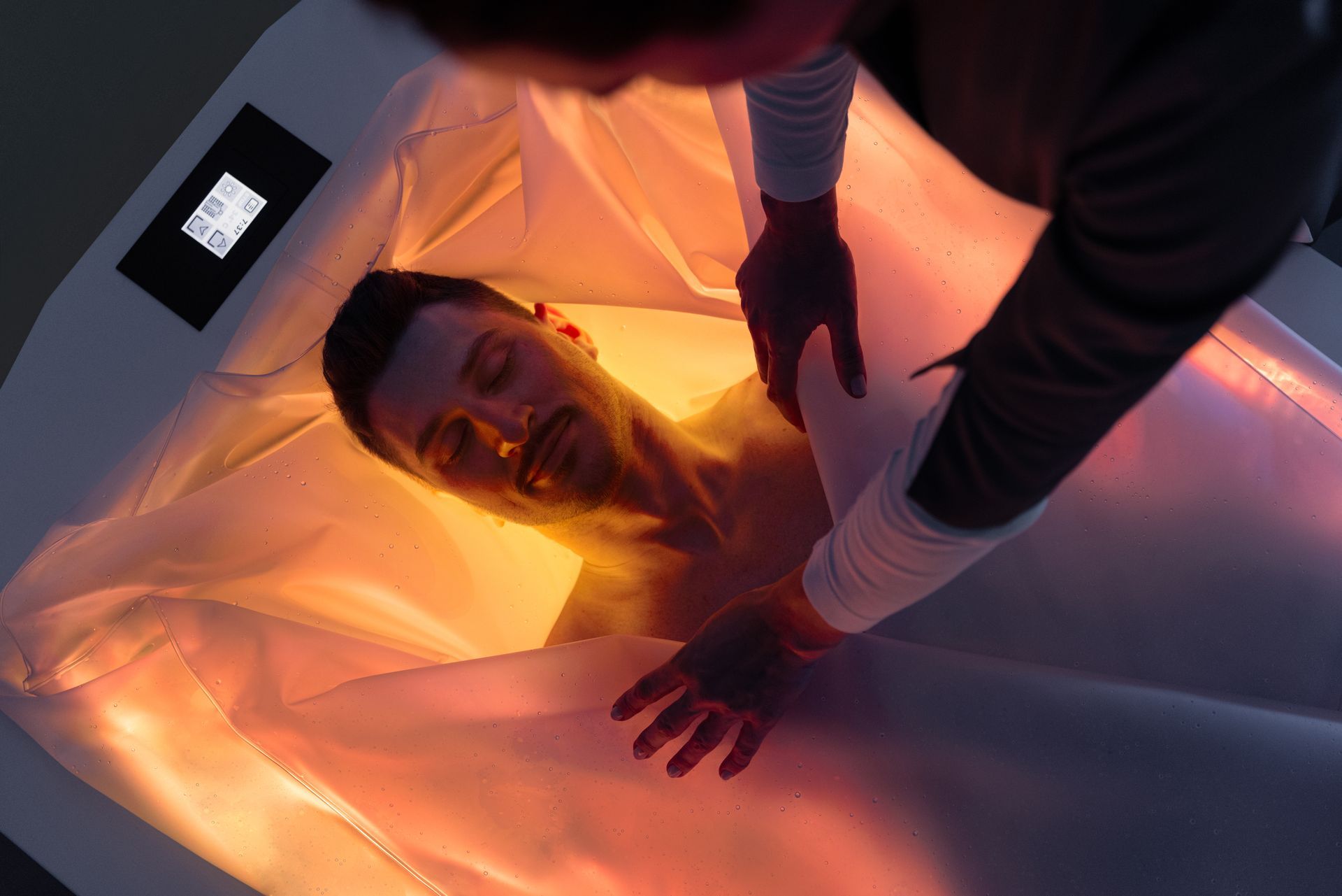 Un uomo giace in una vasca da bagno con una luce sul corpo.