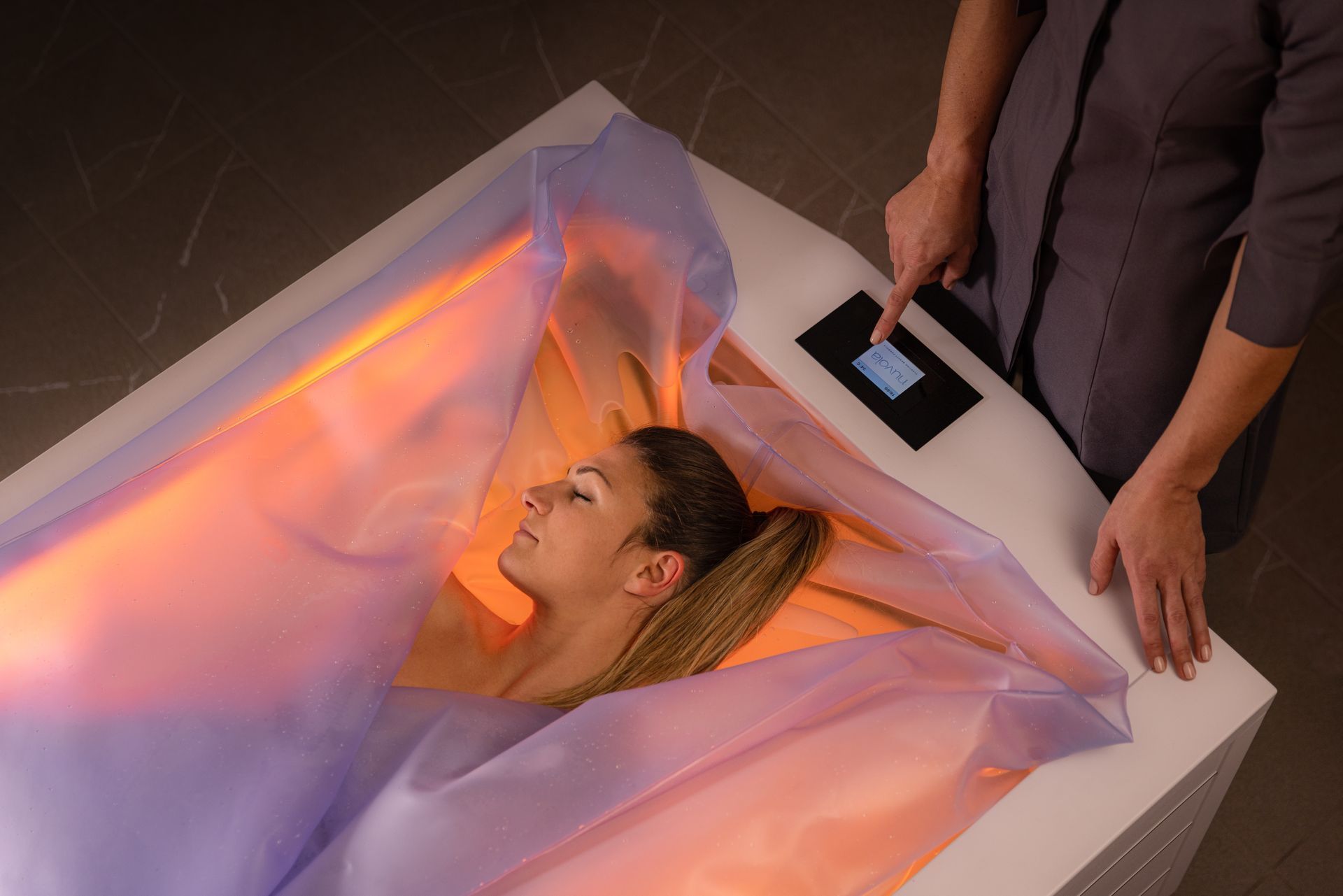 Una donna giace in una vasca da bagno avvolta in una coperta.