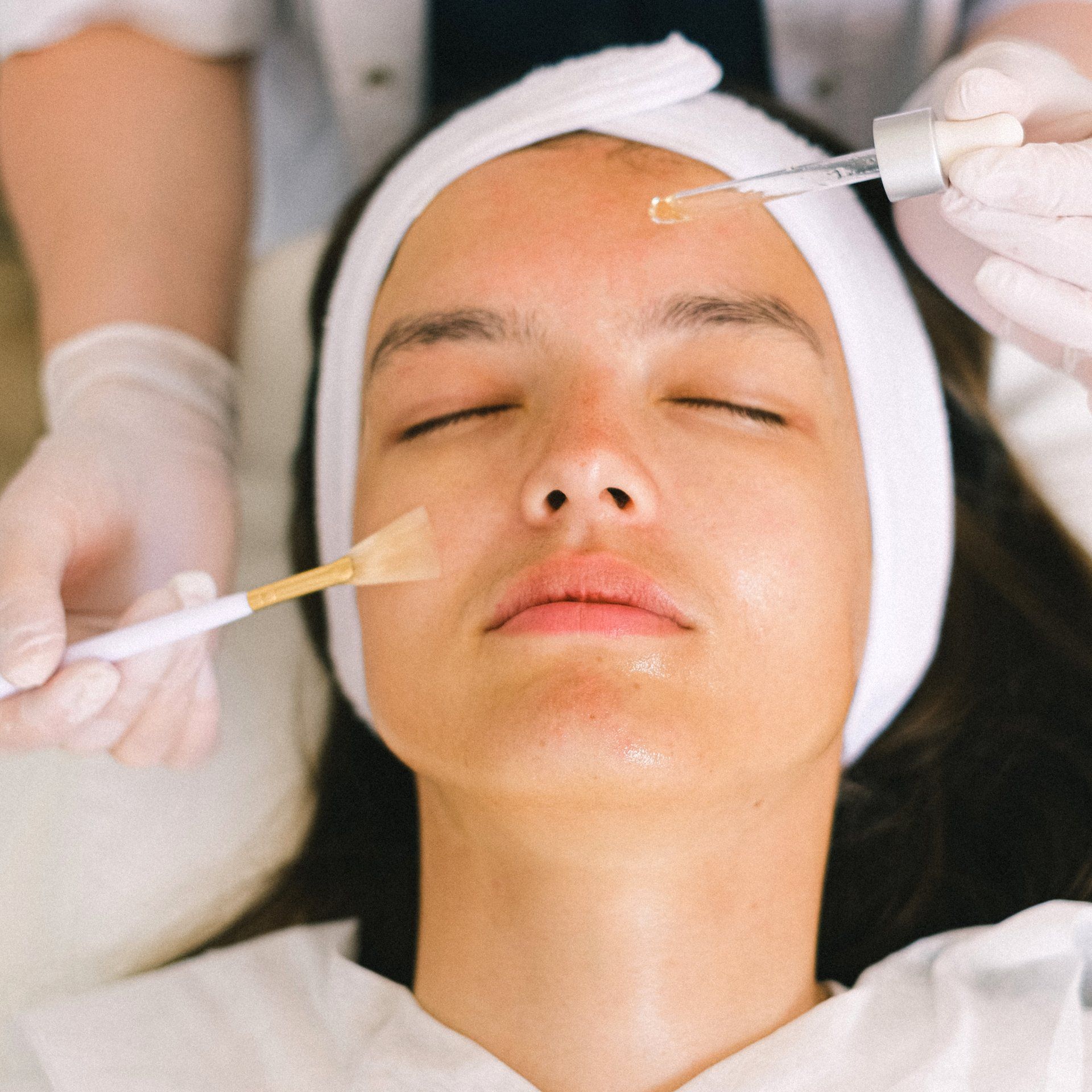 Una donna sta ricevendo un trattamento viso con una spazzola sul viso.