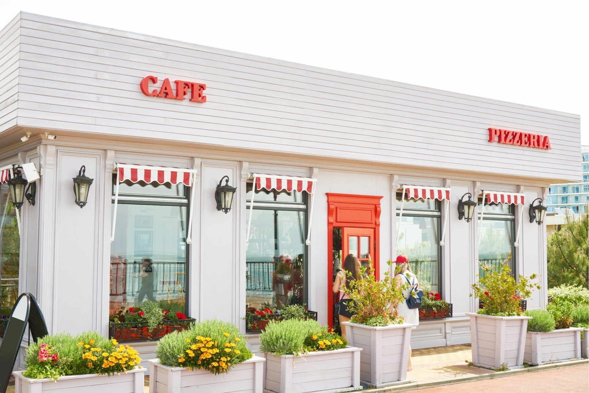 White cafe with red door, awnings, and