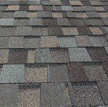 Close-up view of a shingled roof with a blend of gray and brown tones.