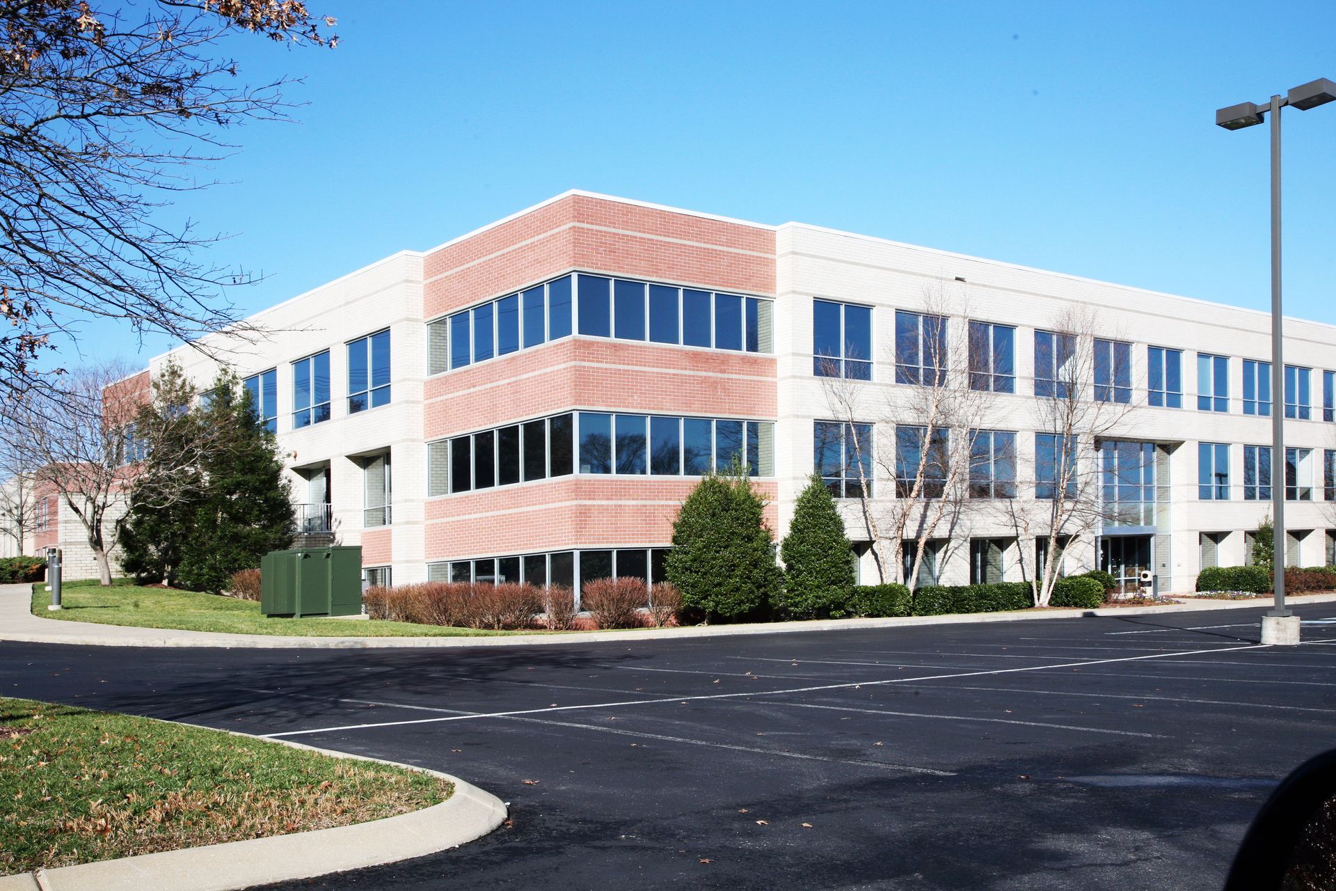 Office building with brick and large windows on a sunny day.
