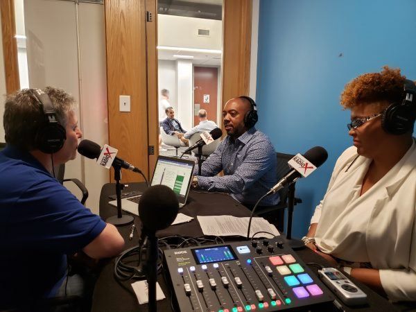 A group of people are sitting at a table with microphones in front of them