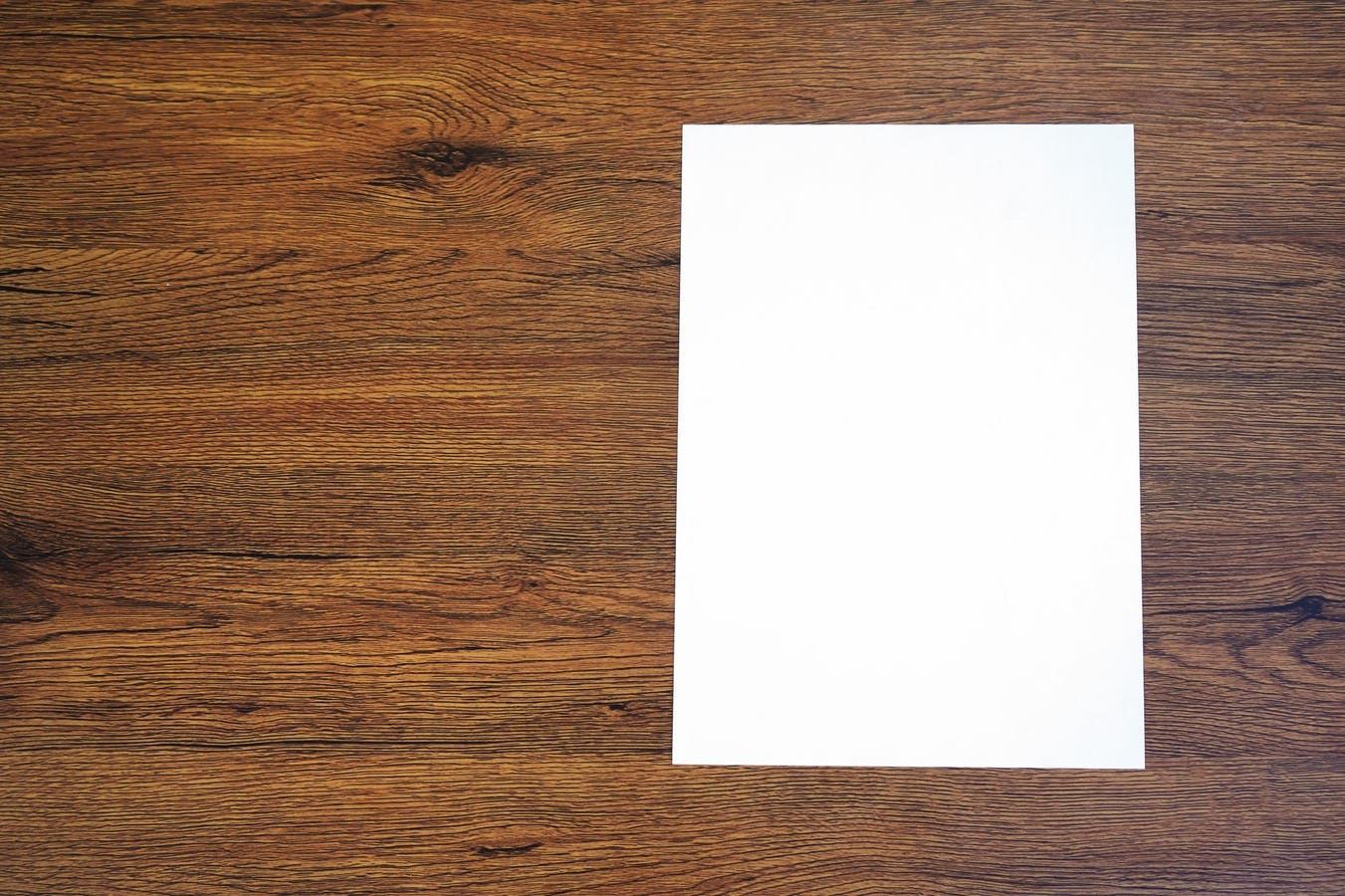 A white piece of paper is sitting on a wooden table.