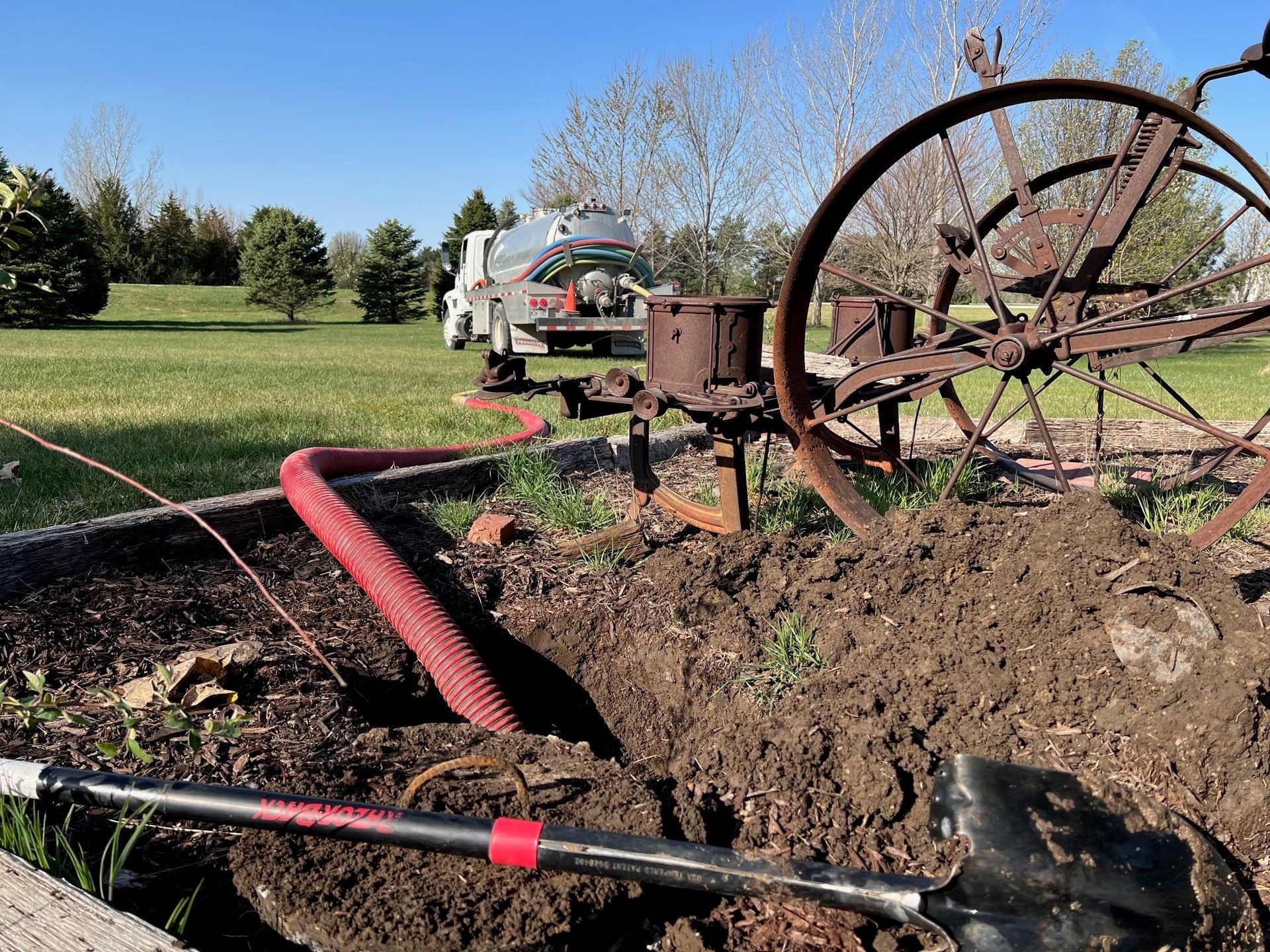 A truck site in a field running hose to a septic tank.