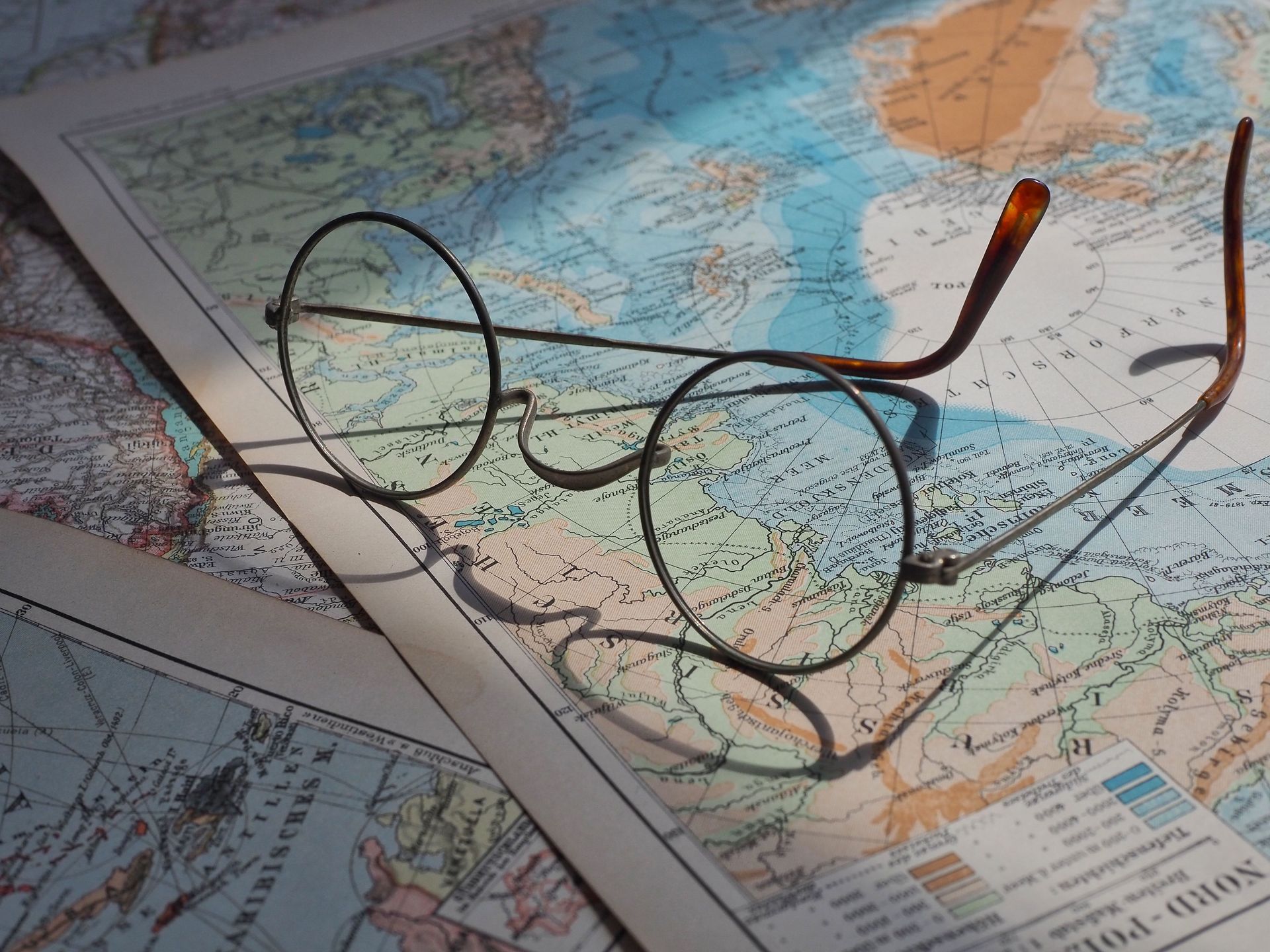 Eyeglasses resting on a folded map with a pen, suggesting travel planning