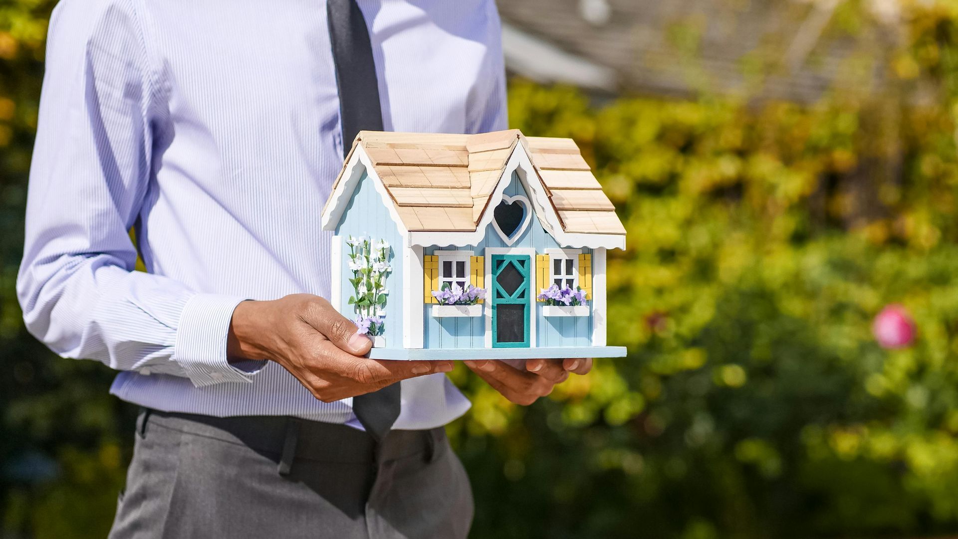 Landlord handing over a wooden model of a house