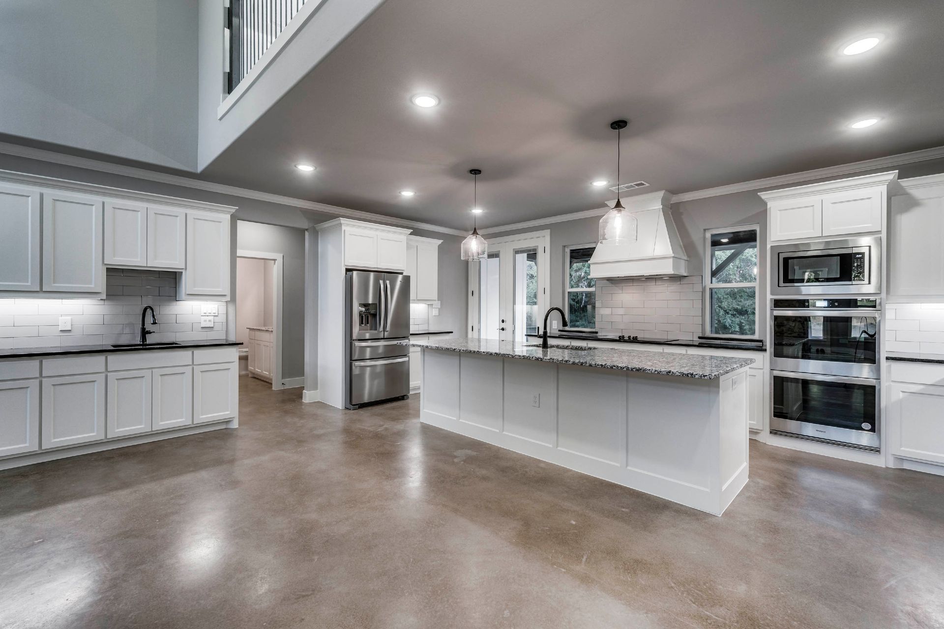 open concept kitchen with large island and white cabinetry