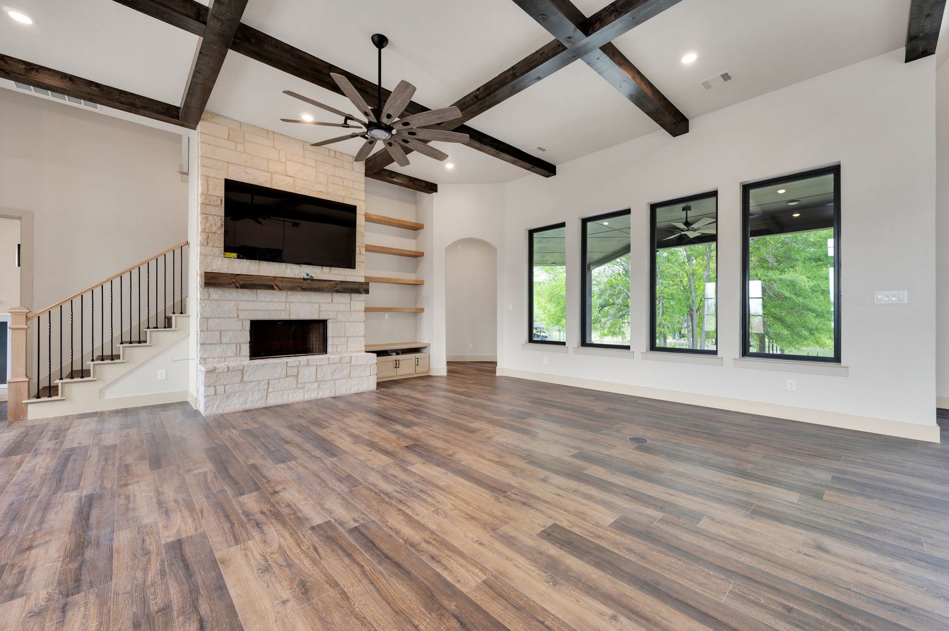 living room with exposed beams and stone fireplace