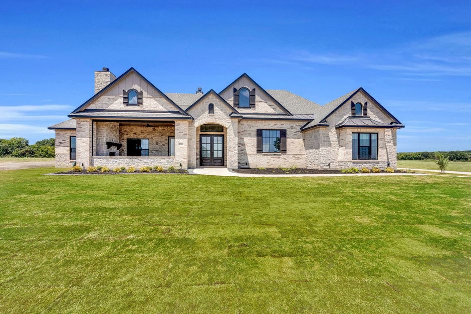 custom home exterior with large front lawn