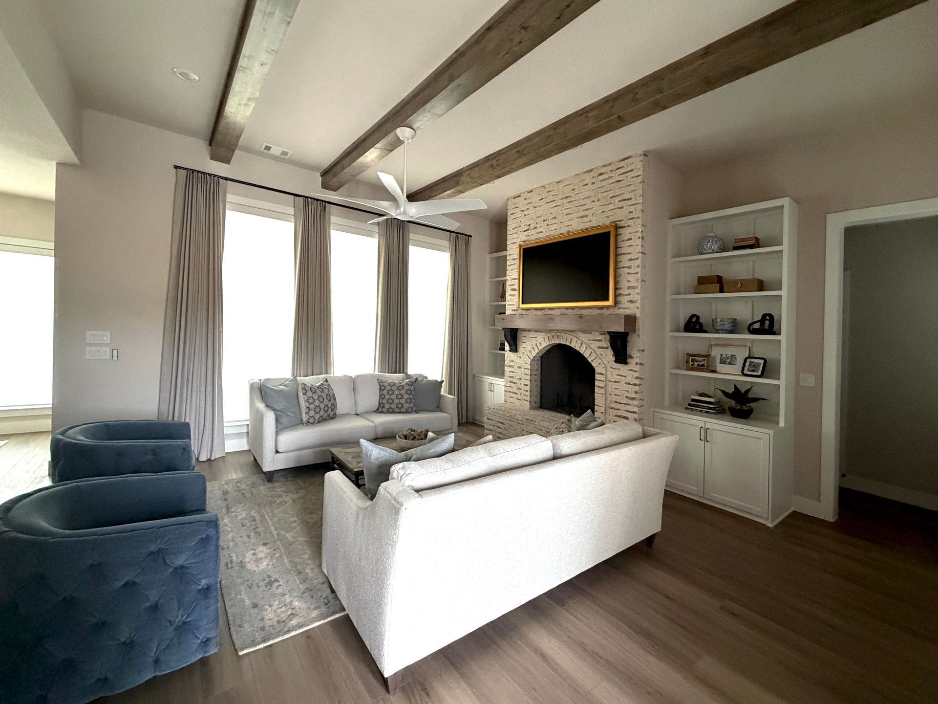 living room with exposed beams and stone fireplace