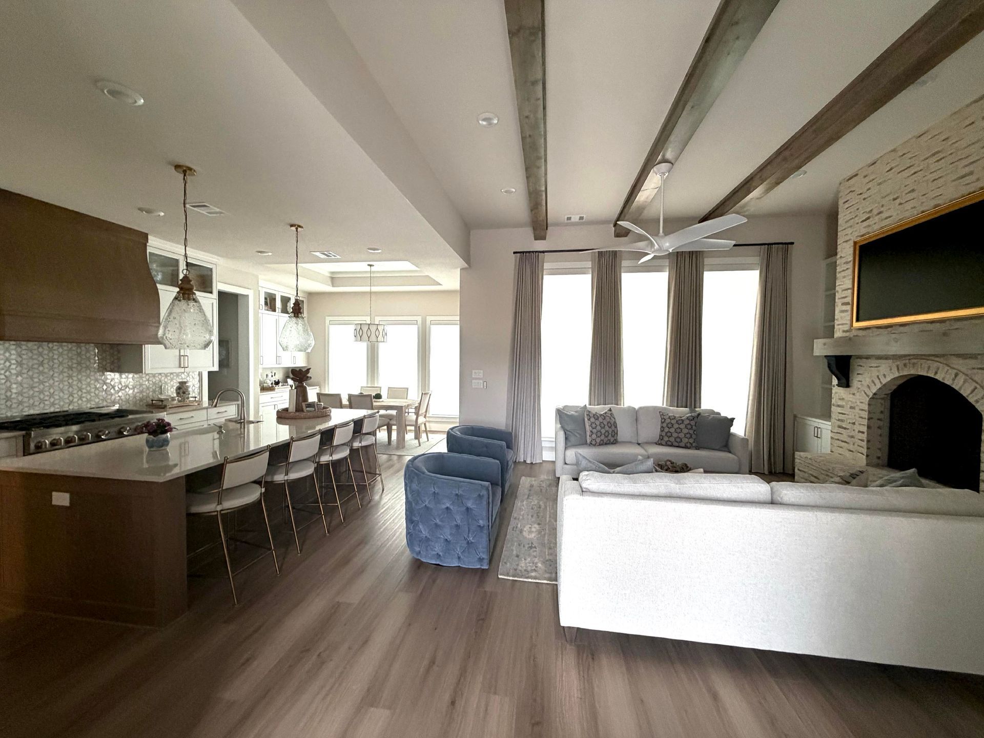 open concept living room with exposed beams and custom kitchen