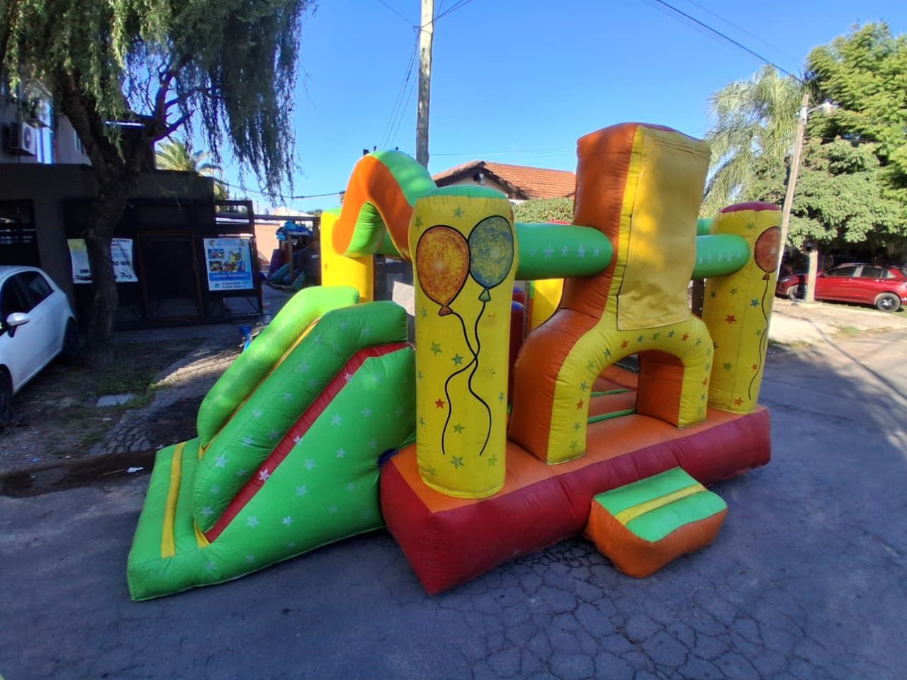 Conjunto de castillo hinchable y tobogán de colores para disfrutar al aire libre en un día soleado.