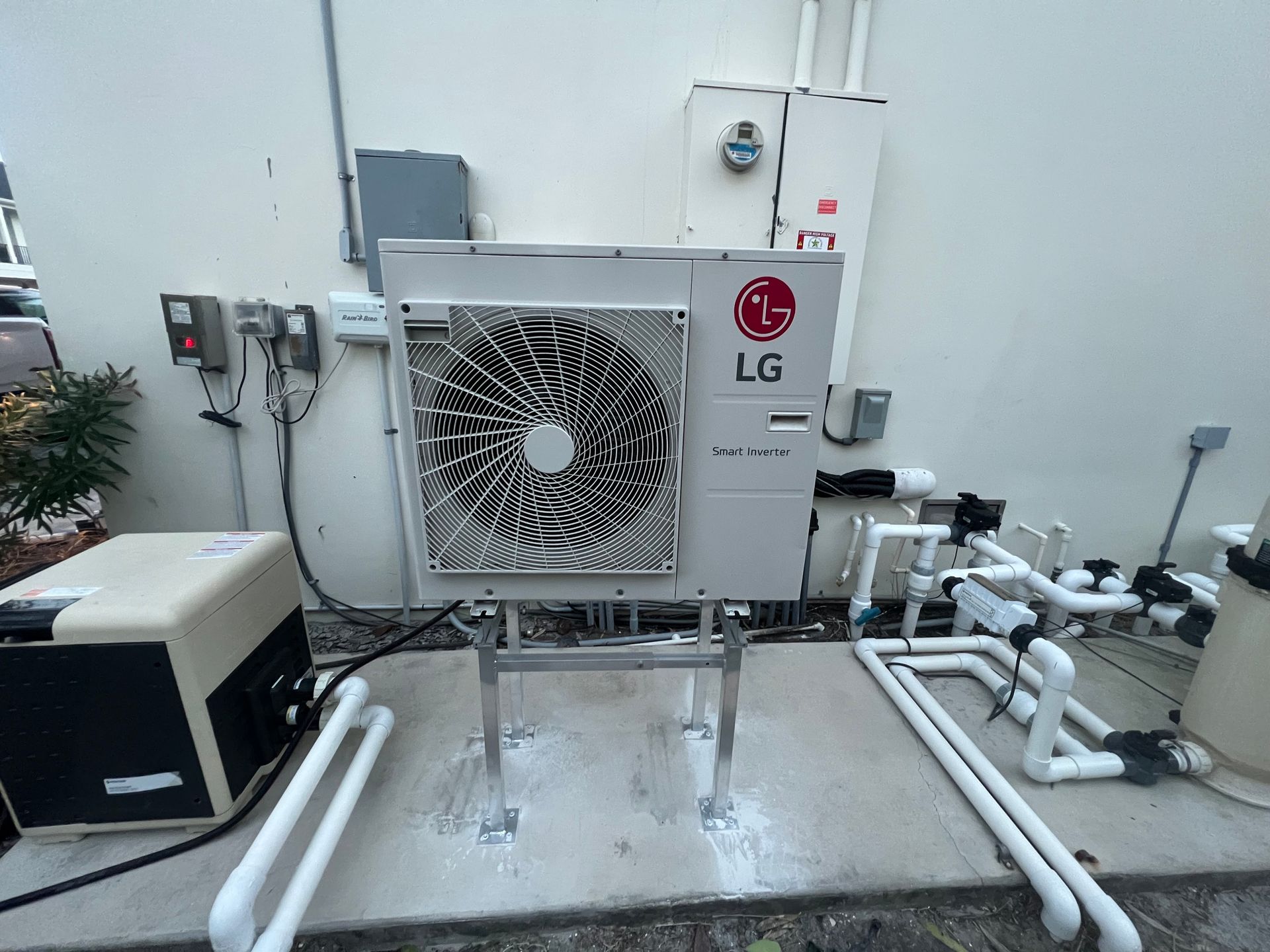 LG pool heat pump outside with pipes and electrical components.