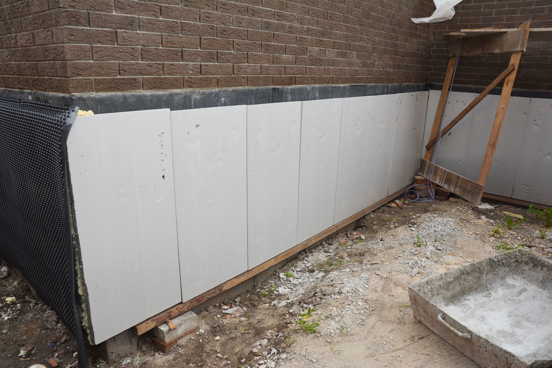 A brick wall with a lot of white boards on it is being built.