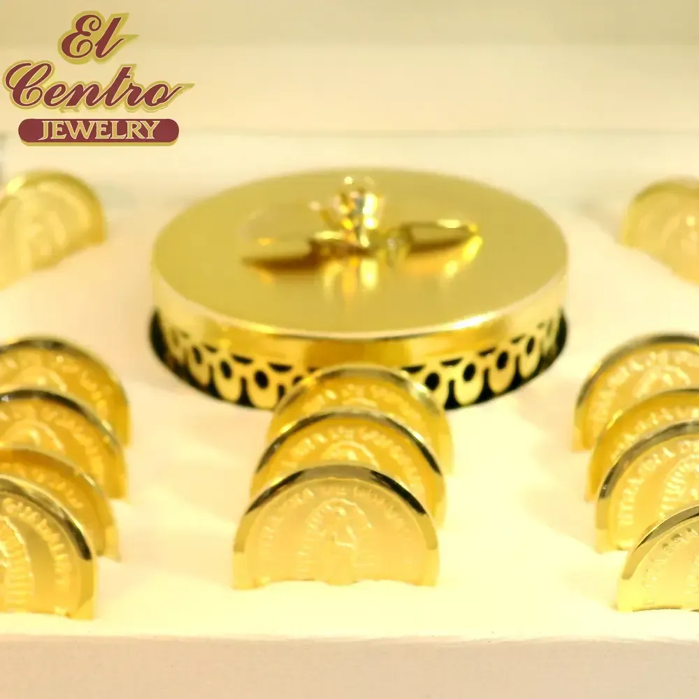 Gold jewelry display with rings and a central decorative piece on a white background, El Centro Jewelry logo