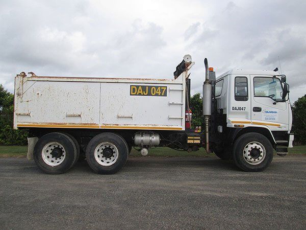 A white dump truck with the license plate daj 047