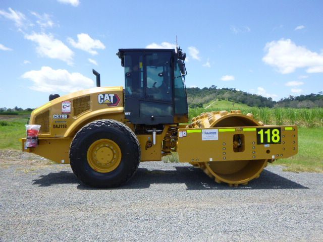 A yellow and black tractor is sitting on top of a trailer.