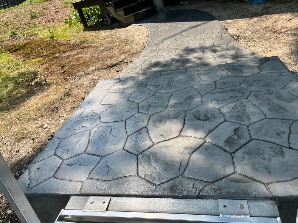 Stamped concrete walkway with a hexagon pattern leading through a yard
