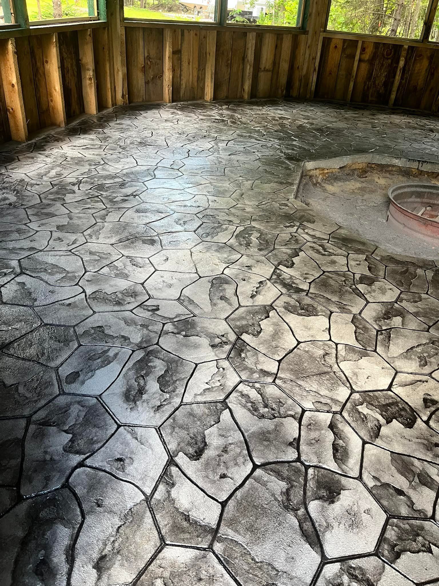 Circular stone floor inside a rustic wooden enclosure, with a raised round stone feature on the right.